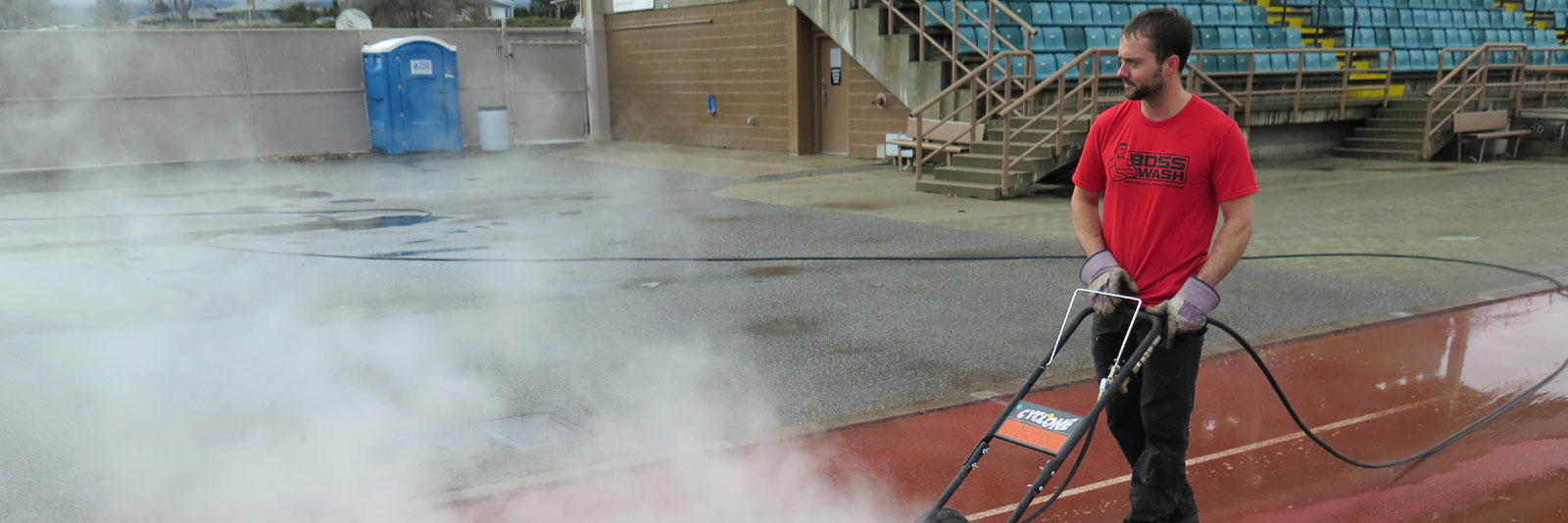 BOSSWASH employee power washing concrete in a stadium